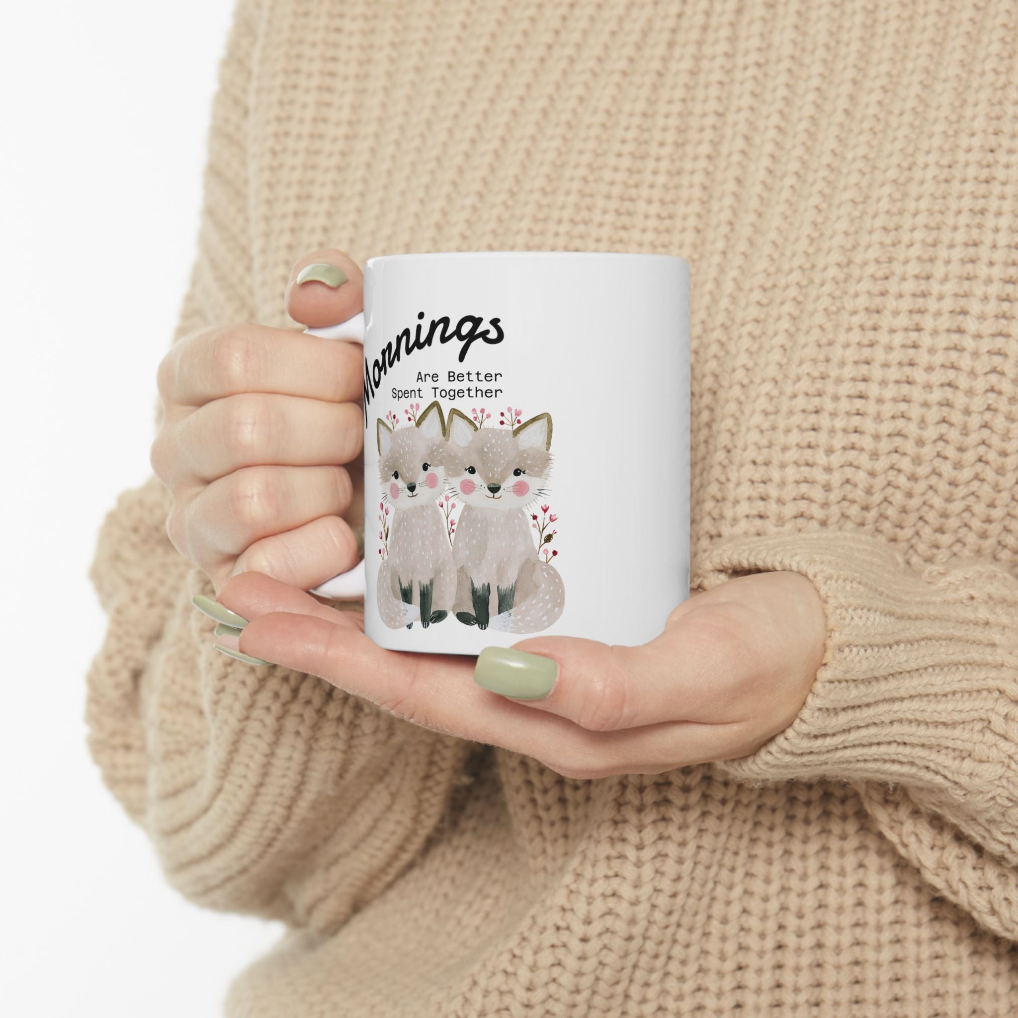 11oz ceramic mug with a fox couple design  held by a person wearing a beige sweater.