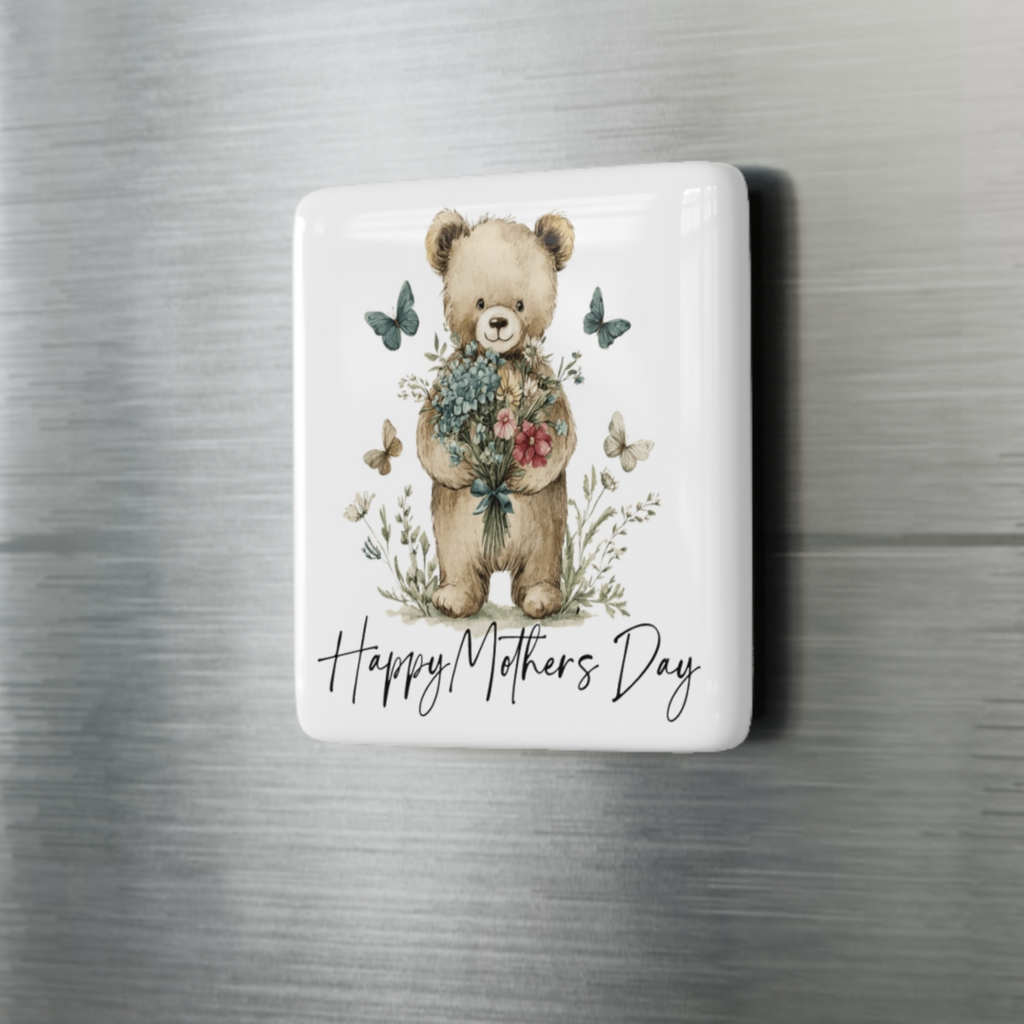 Fridge magnet with a teddy bear holding flowers and butterflies, and 'Happy Mothers Day' text on a metallic surface.