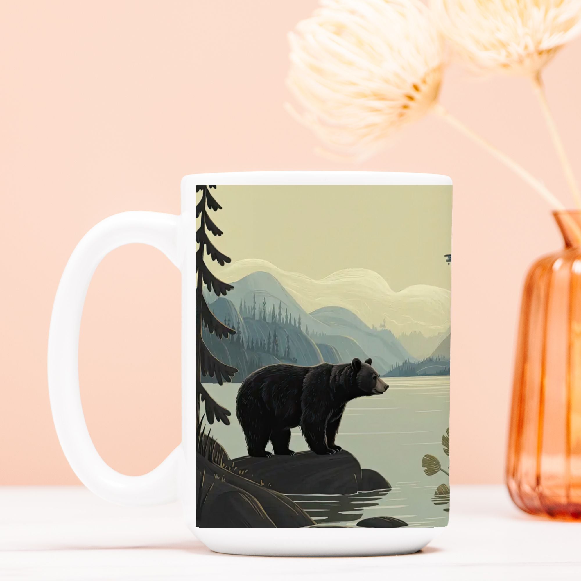 Mug with bear design on a scenic landscape against a peach-colored background