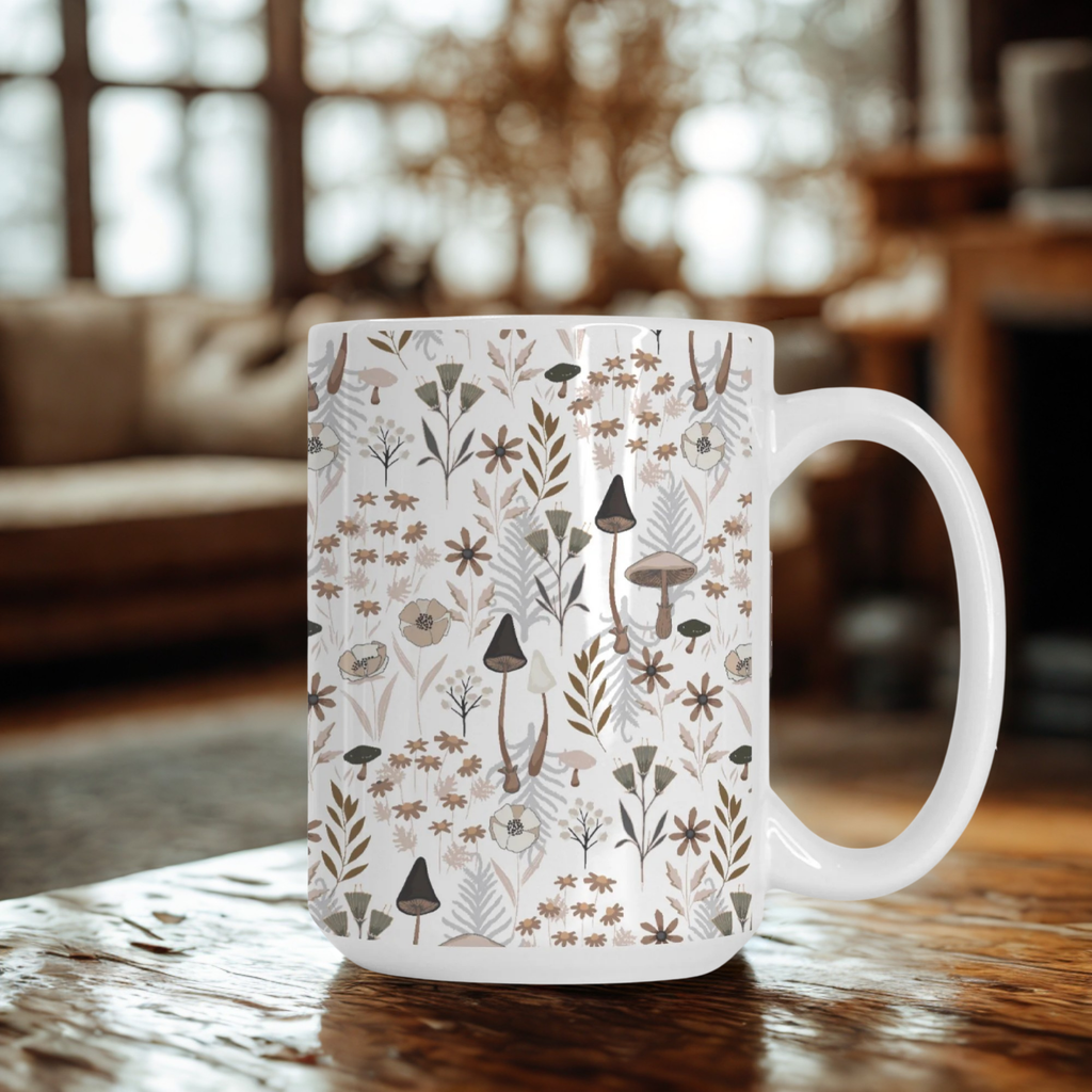 White mug with nature-themed pattern on a wooden table in a cozy room.