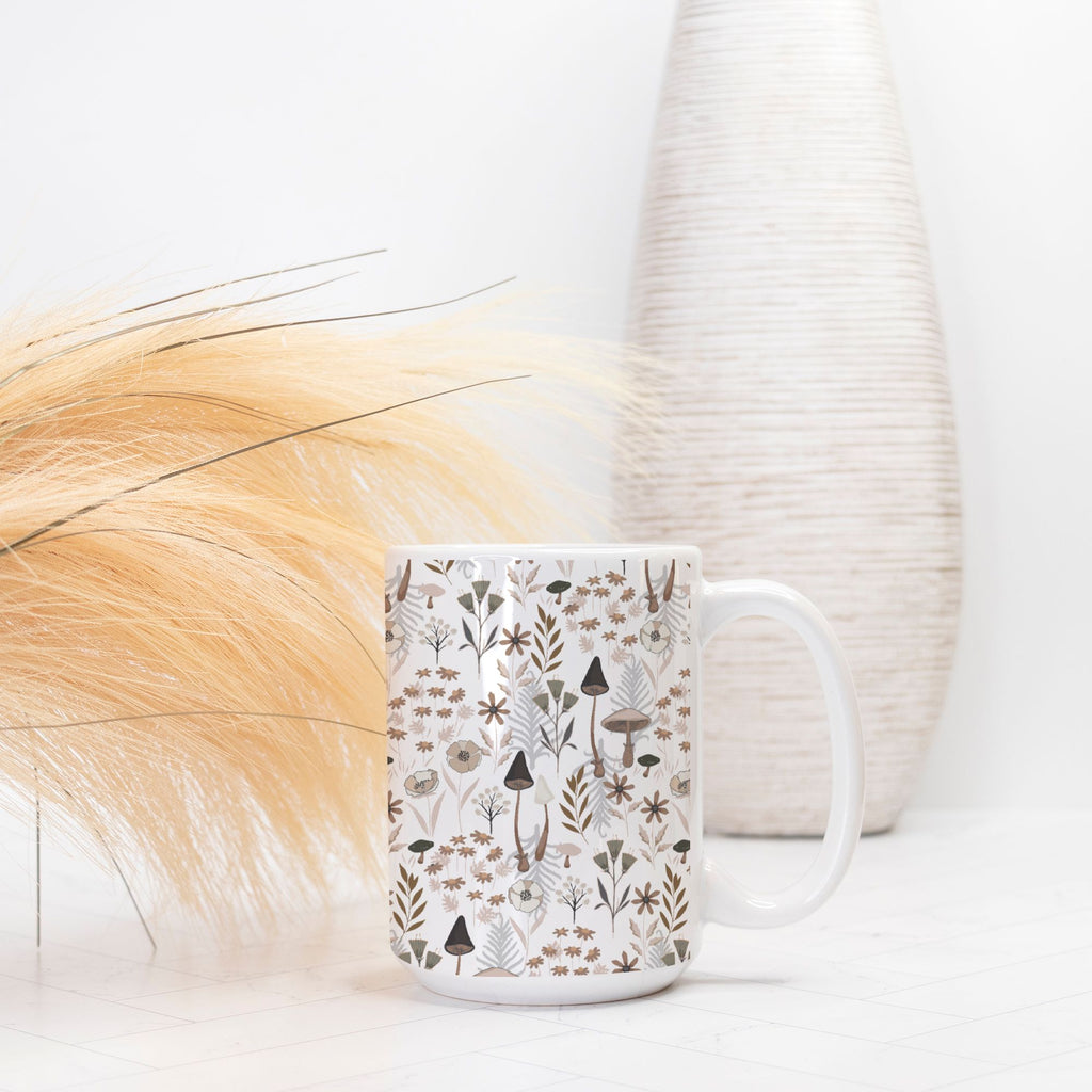 White mug with nature-themed pattern on a white surface with decorative elements