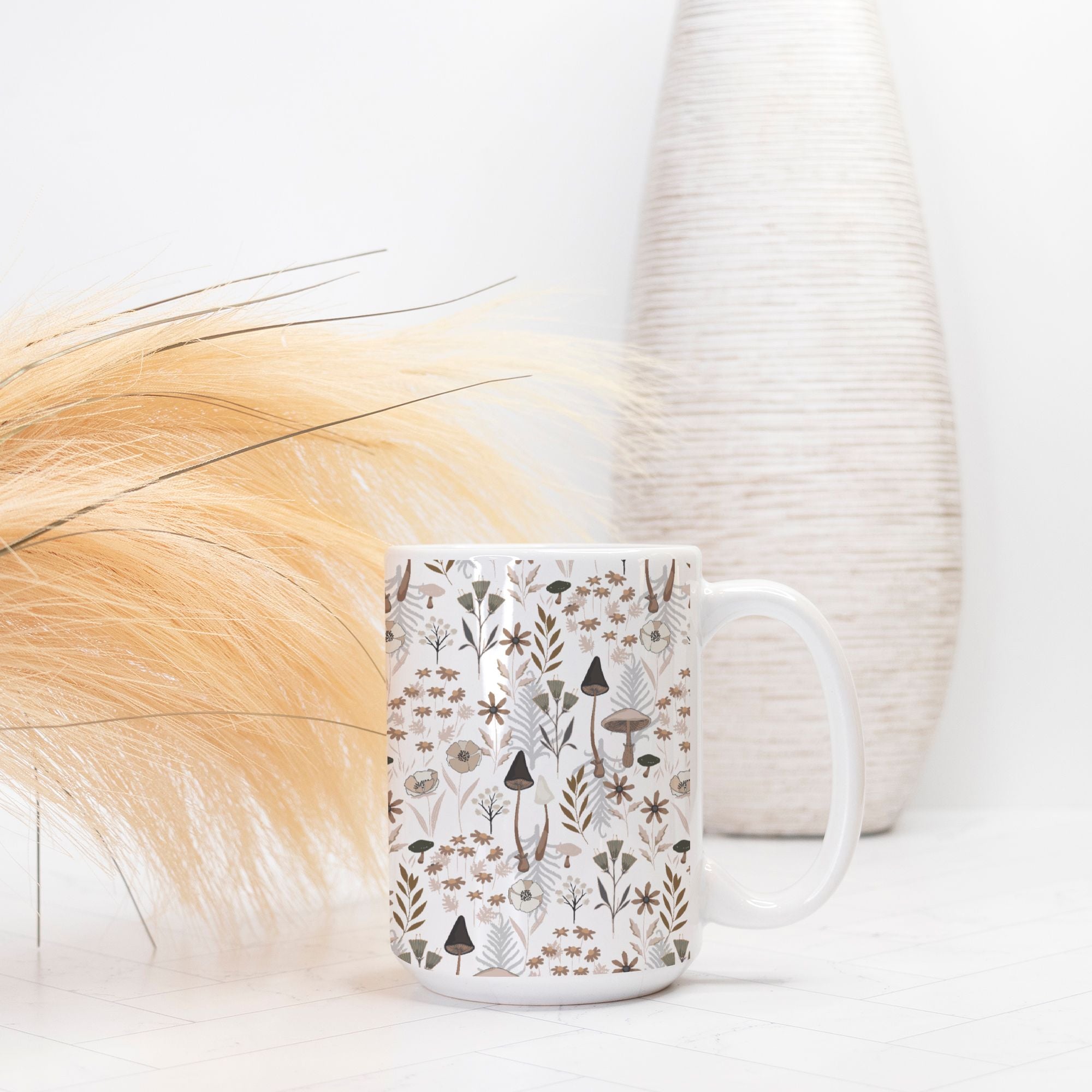 White mug with nature-themed pattern on a white surface with decorative elements