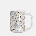 White mug with a nature-themed pattern featuring plants and mushrooms on a white background