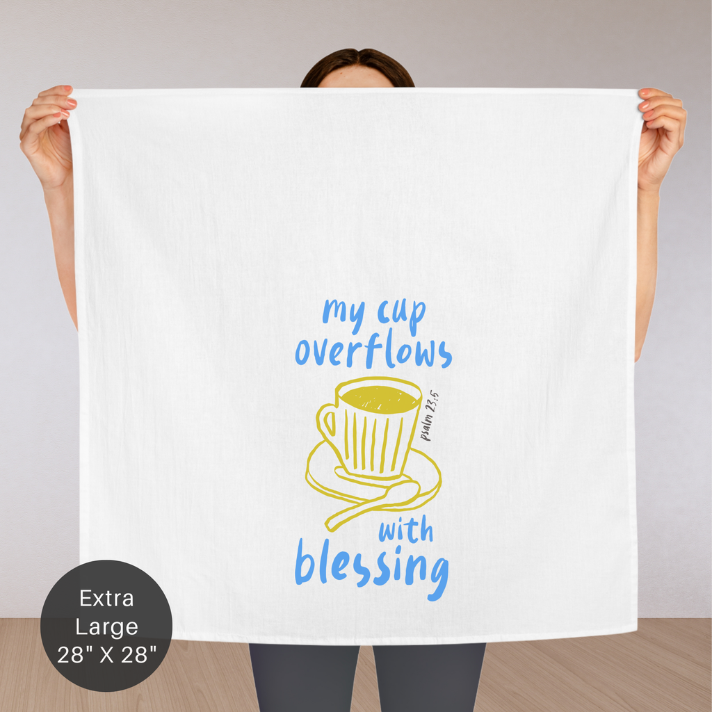 Person holding an extra large white tea towel with a cup design and text.