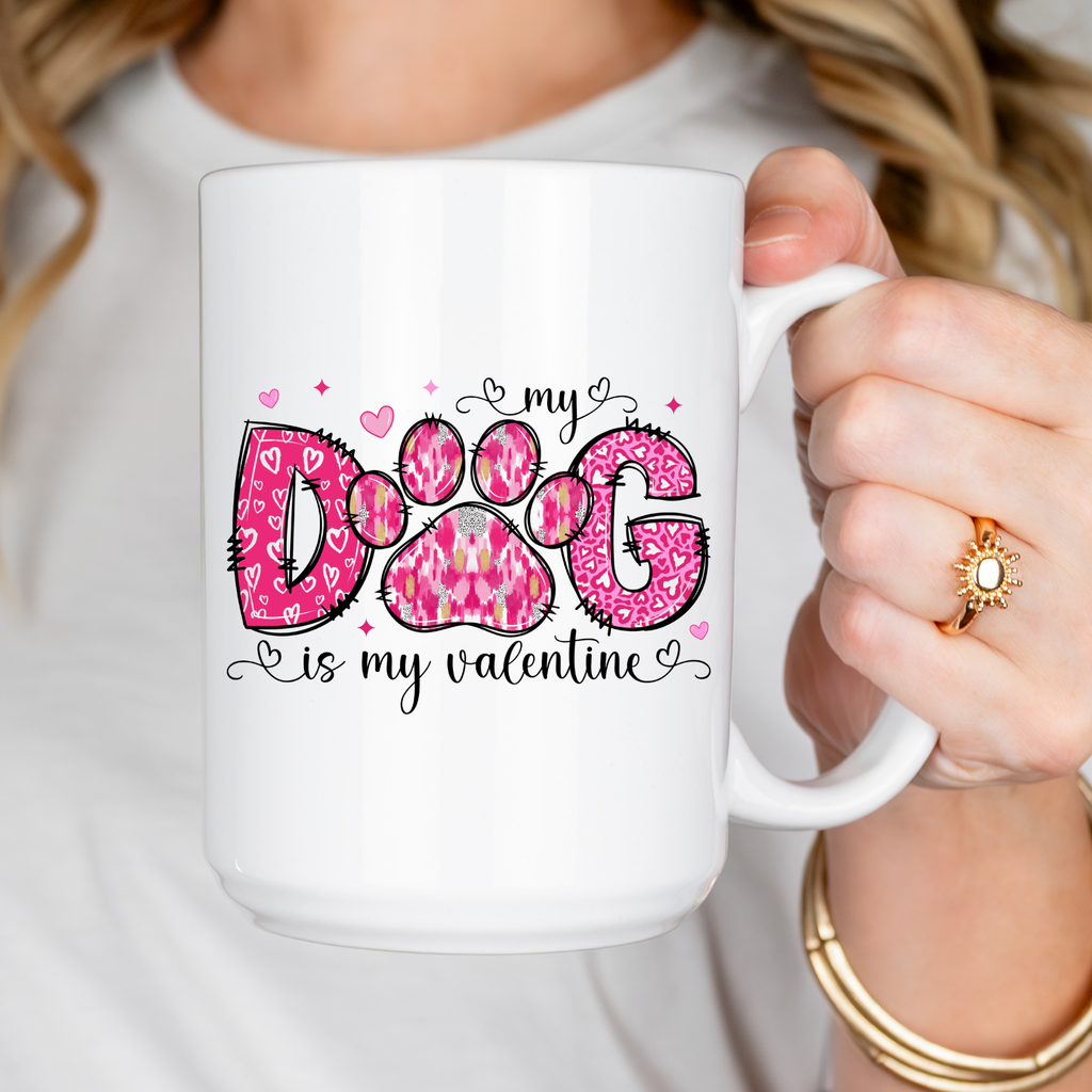 Person holding a white mug with pink paw print design and text