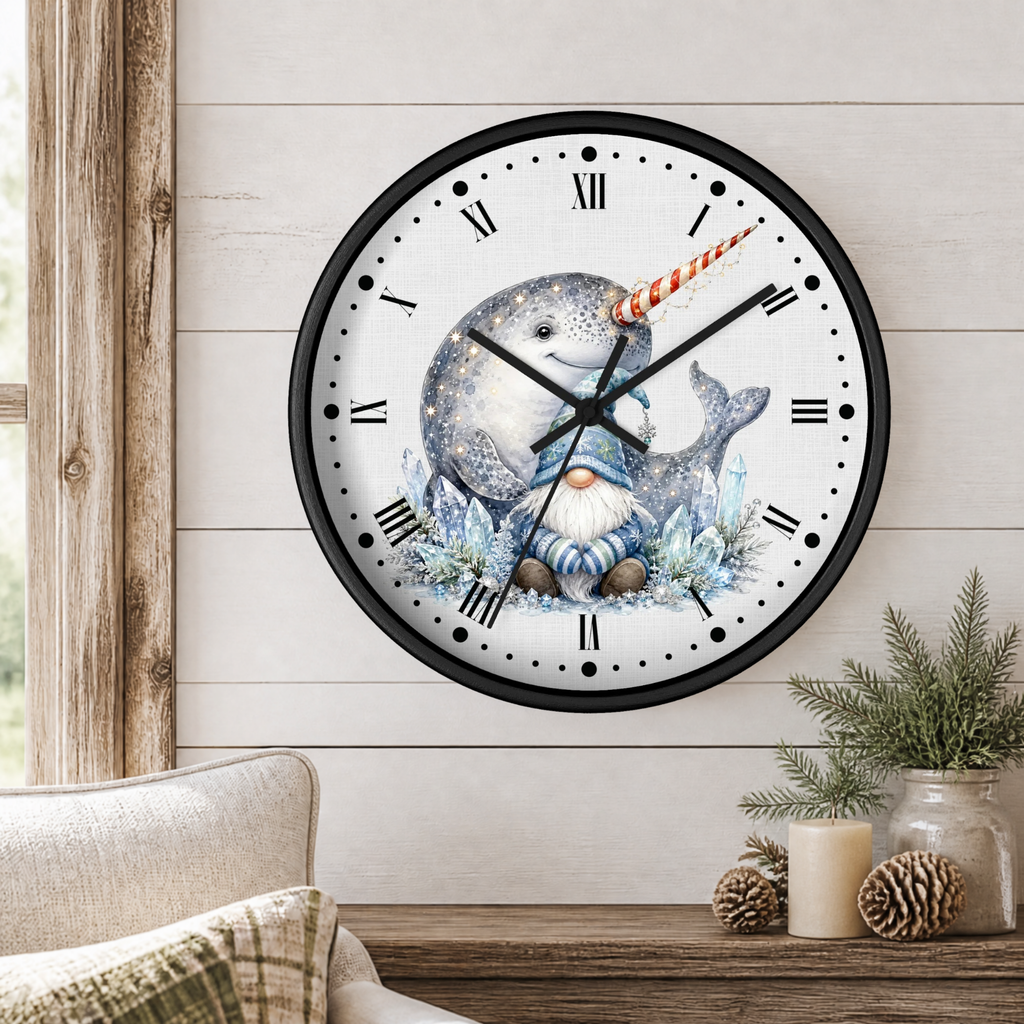 A round wall clock with a black frame and a whimsical illustration of a blue-gray narwhal with a small gnome face on the dial, styled in a cozy room setting with a wood-paneled wall, a chair, and decorative pinecones and candles.