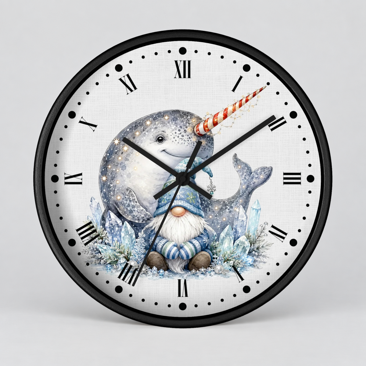 A round wall clock with a black frame and a white face featuring a whimsical illustration of a narwhal, blue ice crystals, and a small gnome. The clock is shown against a neutral light gray background.