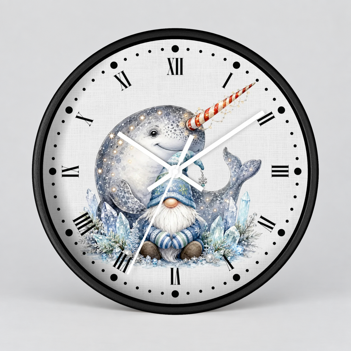 A round wall clock with a black frame and a white face featuring a whimsical illustration of a blue-gray narwhal with a red-and-white striped horn, a small gnome in blue clothing, and icy blue plants. The clock uses black Roman numerals and white hands against a light gray studio background.