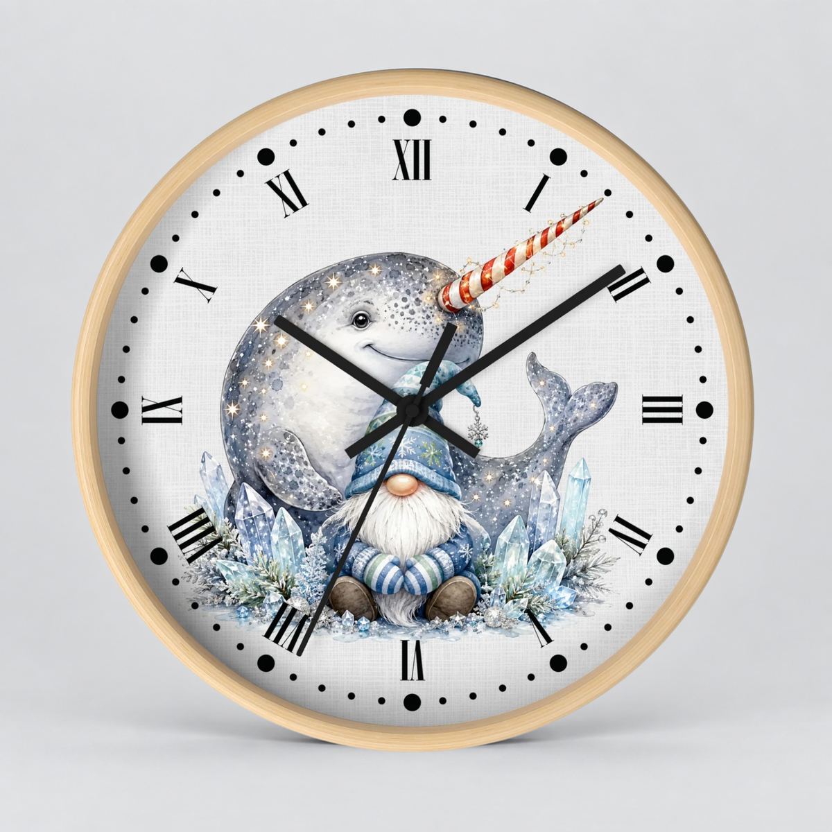 A round wall clock with a light wood frame and a white face featuring an illustration of a narwhal and a small gnome in icy blue tones, shown against a neutral gray background.
