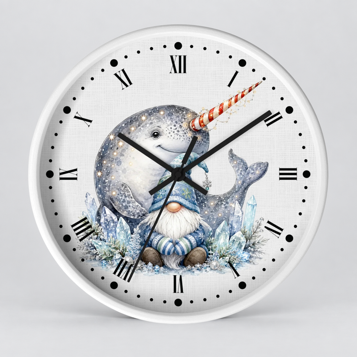 A round wall clock with a white frame and a whimsical mermaid-themed illustration on the face. The artwork shows a gray mermaid with a red-and-white striped horn, a blue-and-white fish, a small gnome in a blue outfit, and icy blue crystals, set against a white background with black Roman numerals and hour markers.