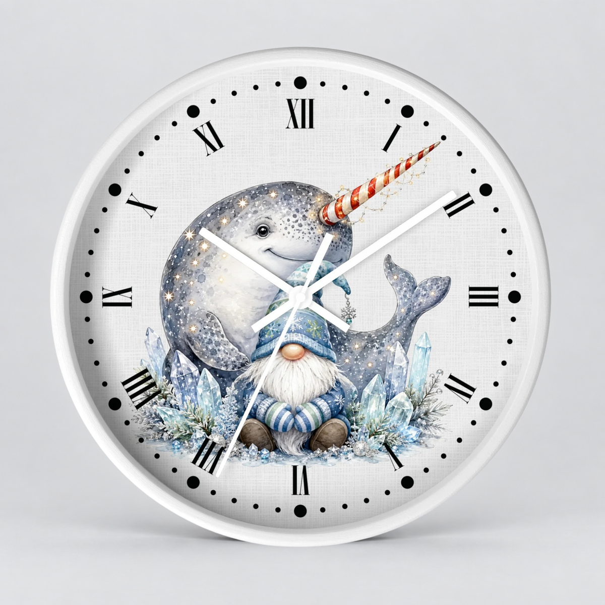 A round wall clock with a white frame and a whimsical illustration on the dial showing a smiling narwhal, a small gnome, and icy blue details, with black Roman numerals and white hands on a light gray background.