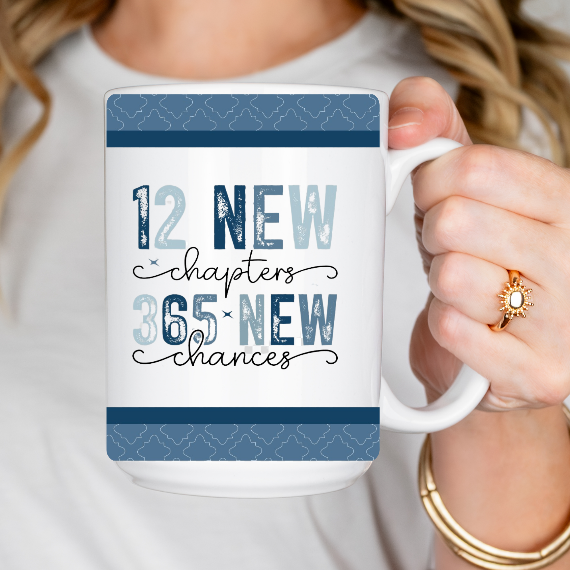 Person holding a mug with motivational quote '12 New chapters, 365 New chances' on a white background