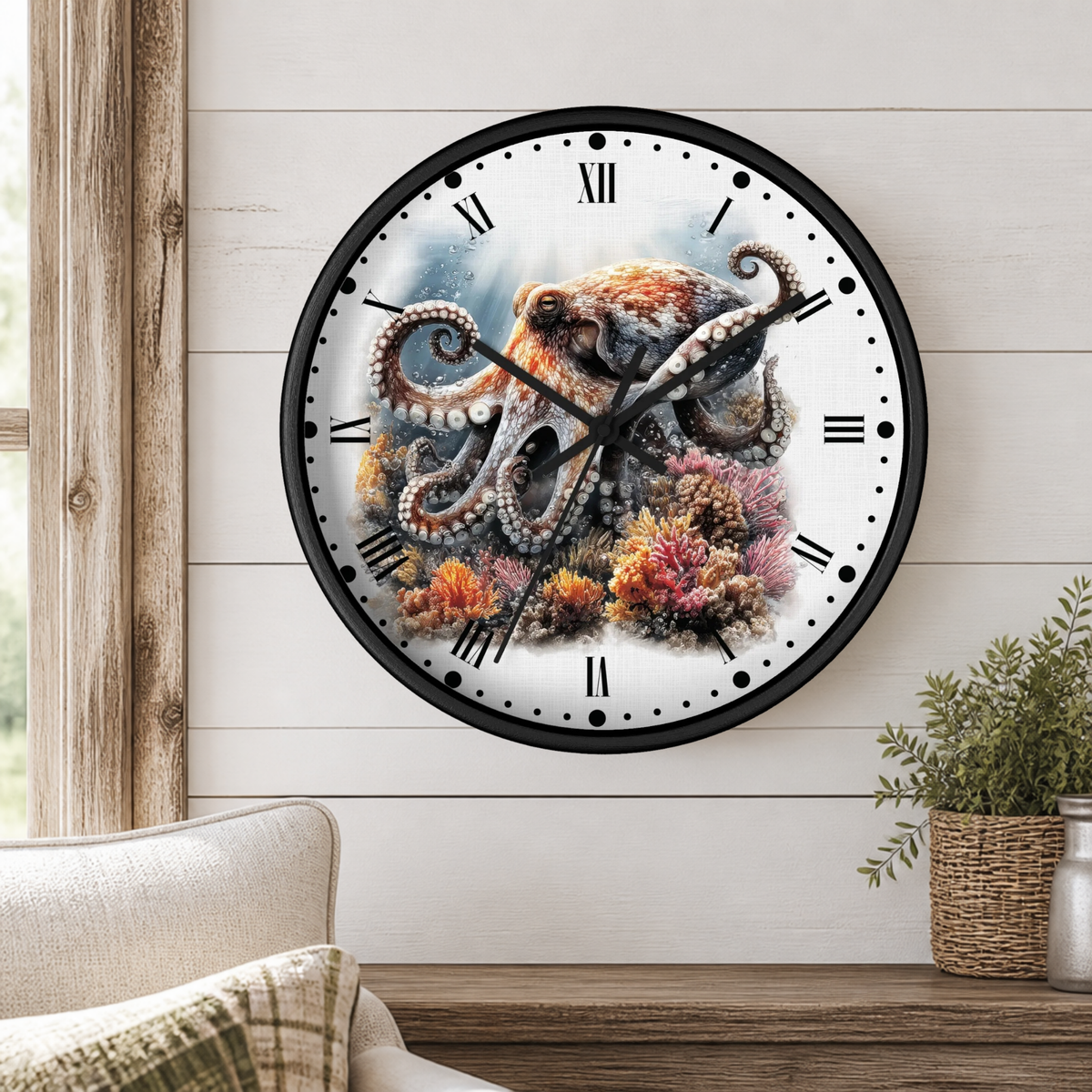 A round wall clock with a black frame and a white face featuring a detailed illustration of an octopus among colorful coral reef marine life, mounted on a white wood-paneled wall above a wooden console table with a plant.