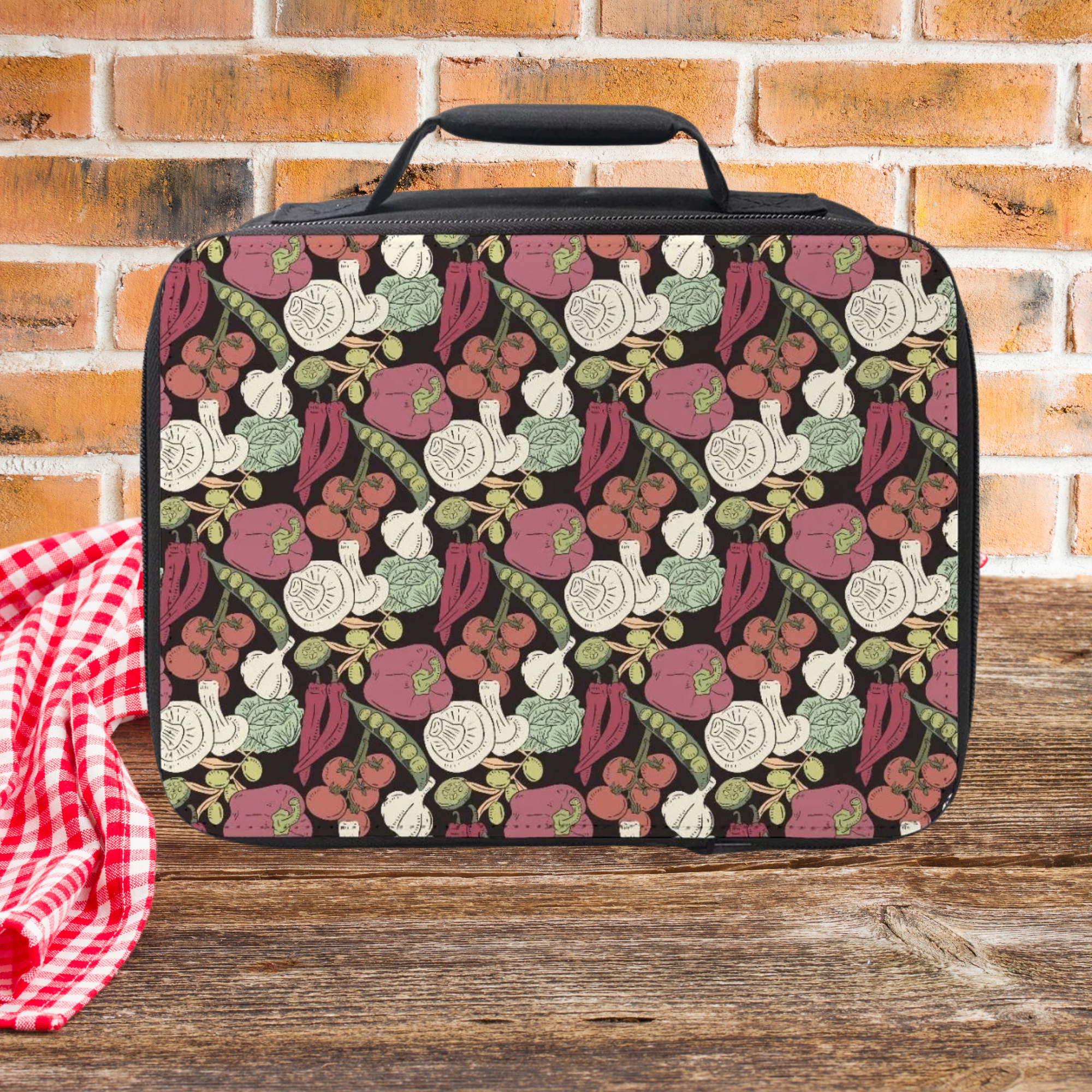 Patterned lunch bag with vegetables on a wooden picnic table and brick wall background