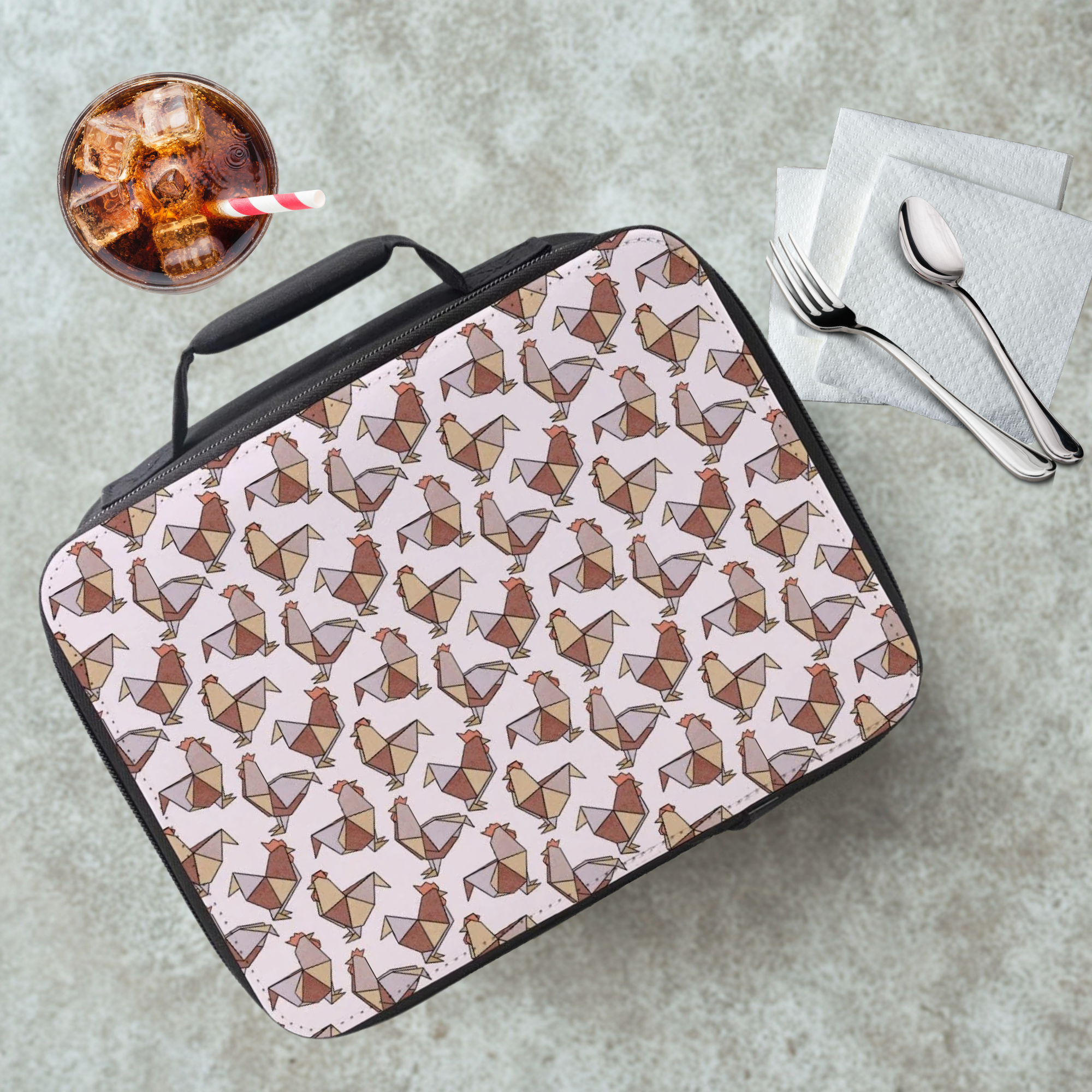 Lunch bag with geometric origami chicken pattern on a cafeteria table with a drink and utensils.