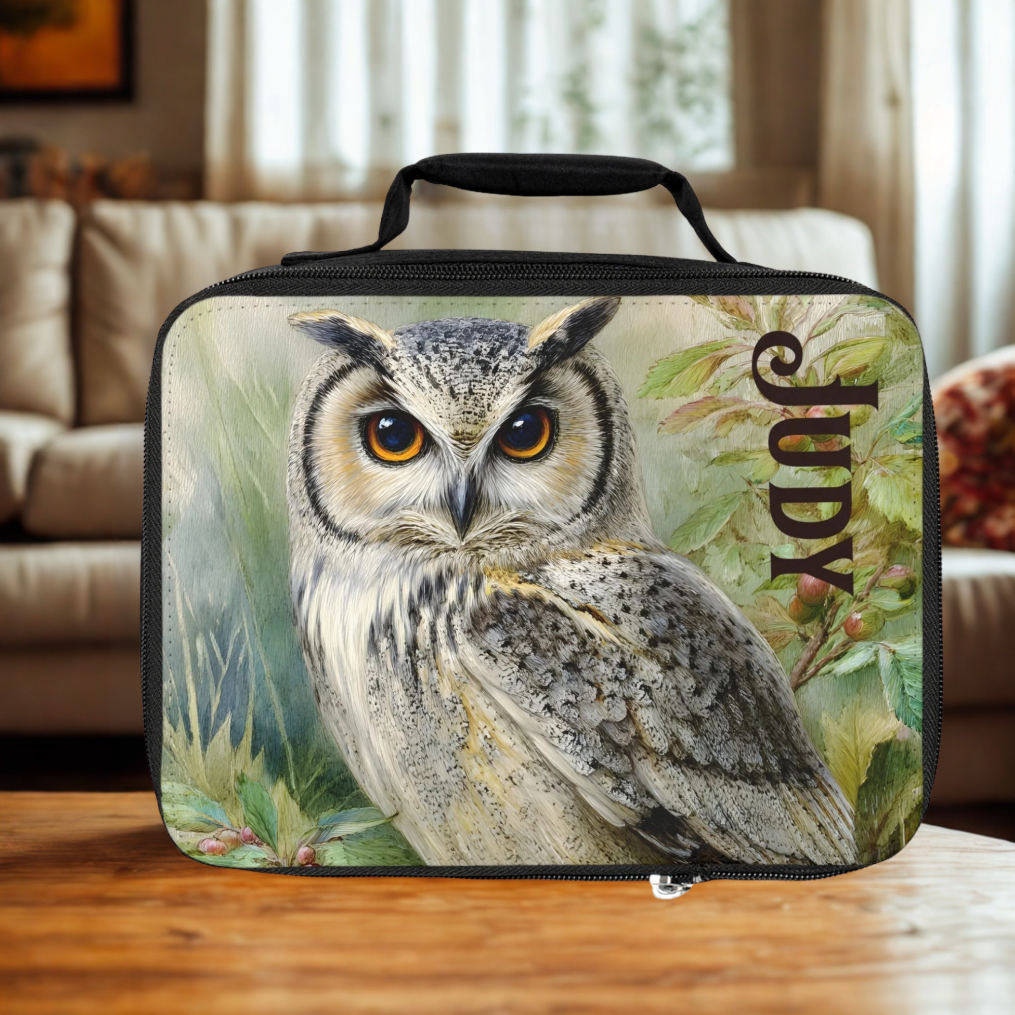  insulated lunch bag with an owl design and the name 'Judy' on a wooden living room table 