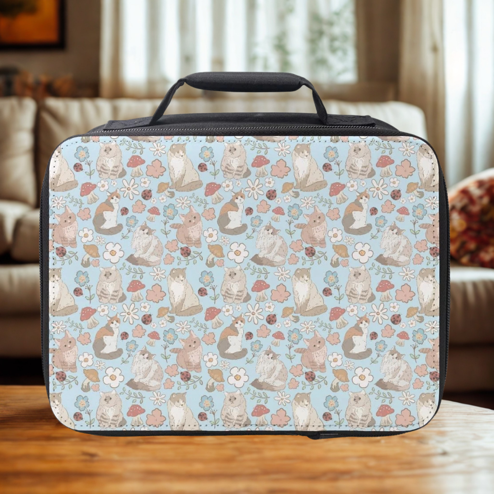 Rectangular lunch bag with cat and floral pattern on a wooden table in a cozy living room.