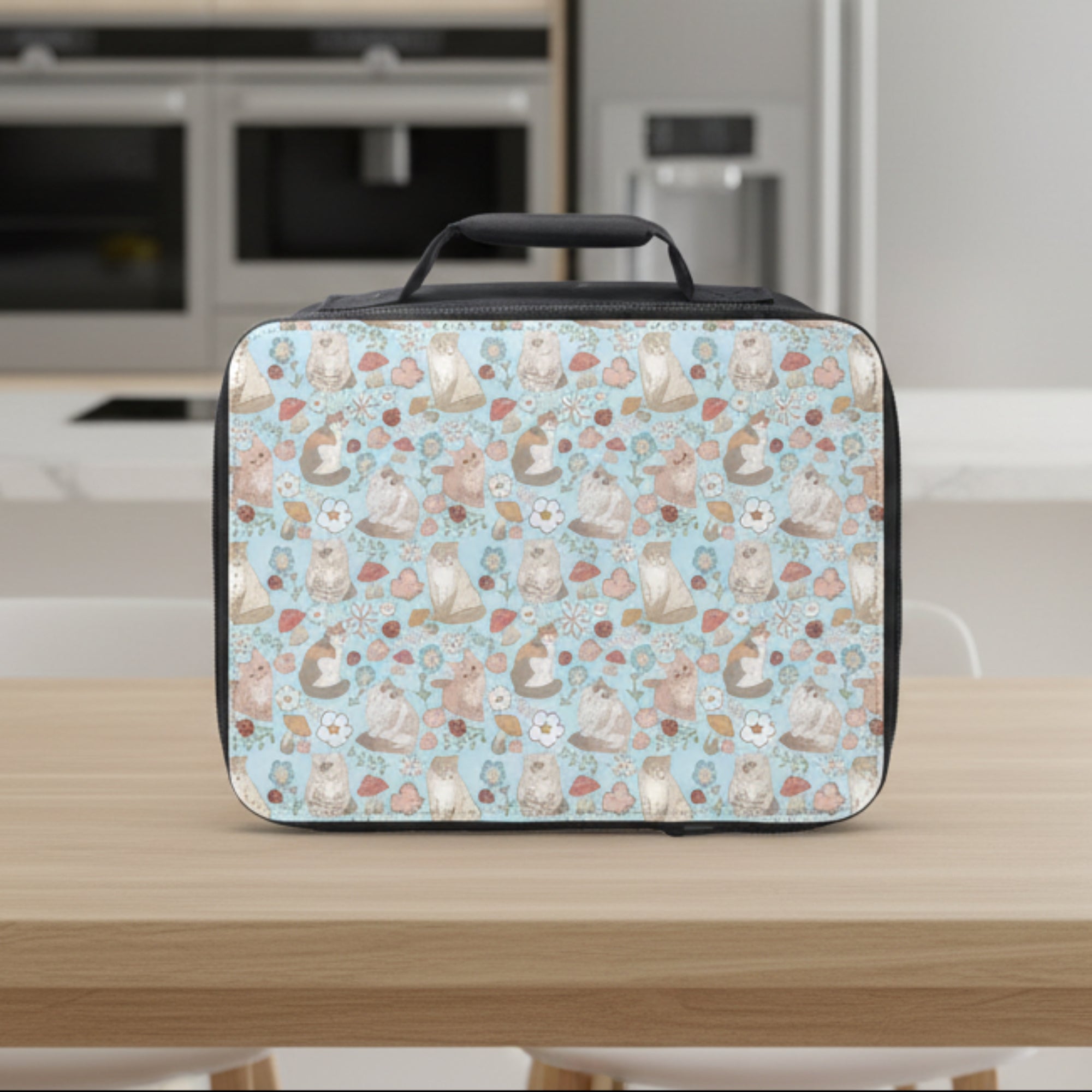 Insulated lunch bag with a pattern of cats, flowers, mushrooms, and ladybugs on a light blue background