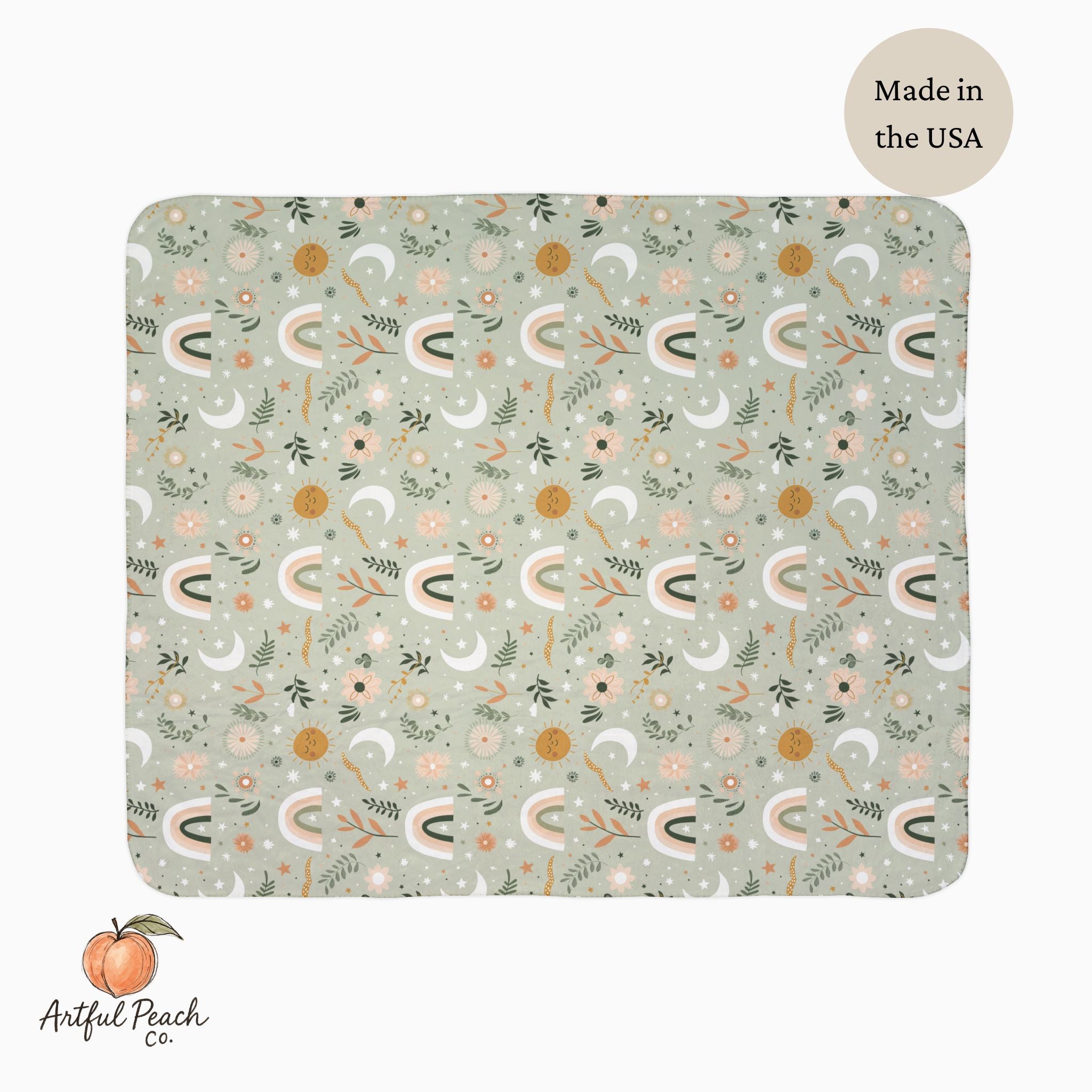 front side of  Patterned blanket with floral and moon designs on a light green background, featuring 'Artful Peach Co.' branding.