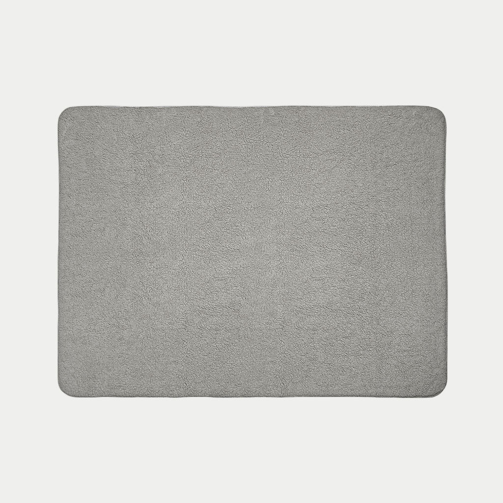 Gray rectangular blanket on a light gray background