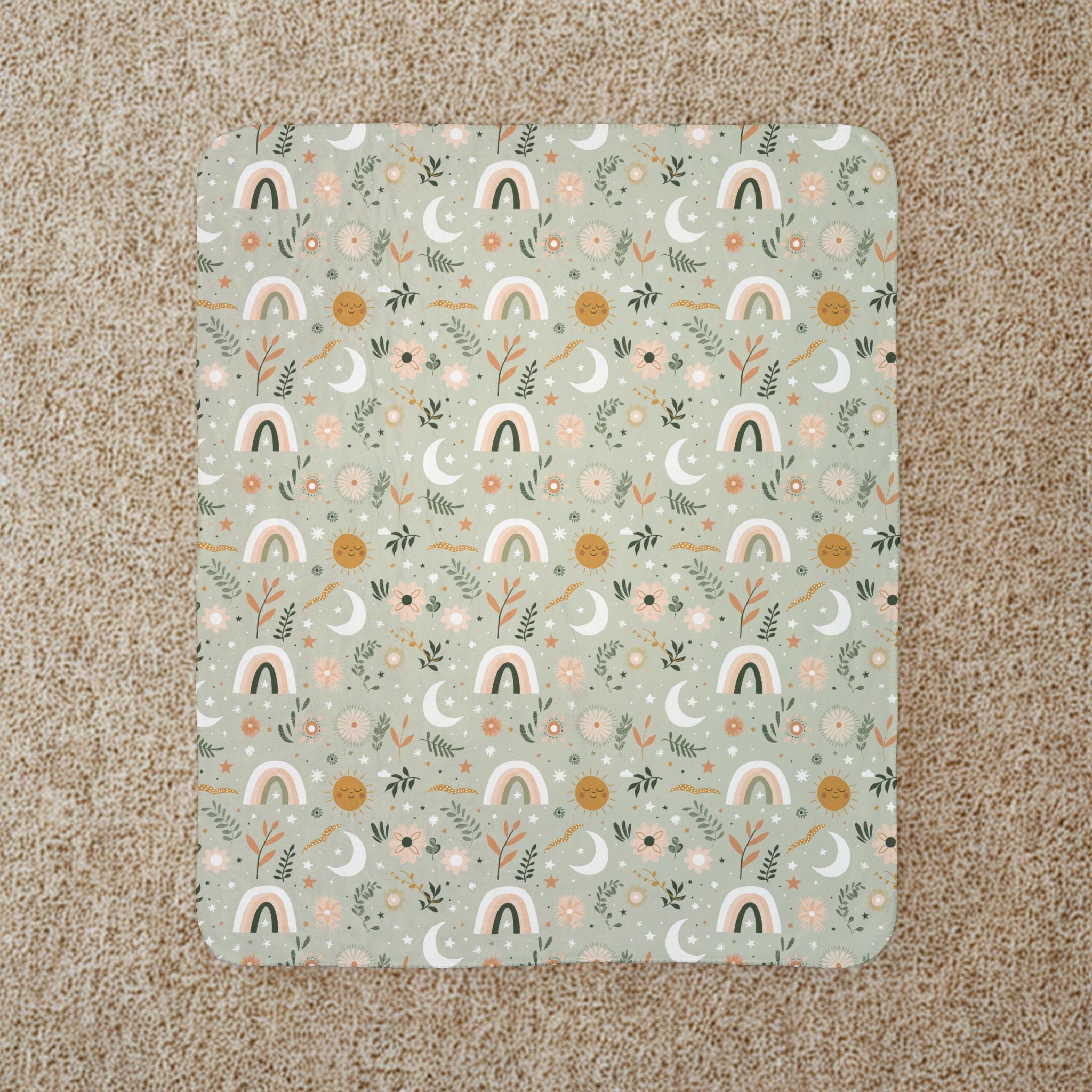 Patterned blanket with rainbows and nature-themed design on a beige carpet
