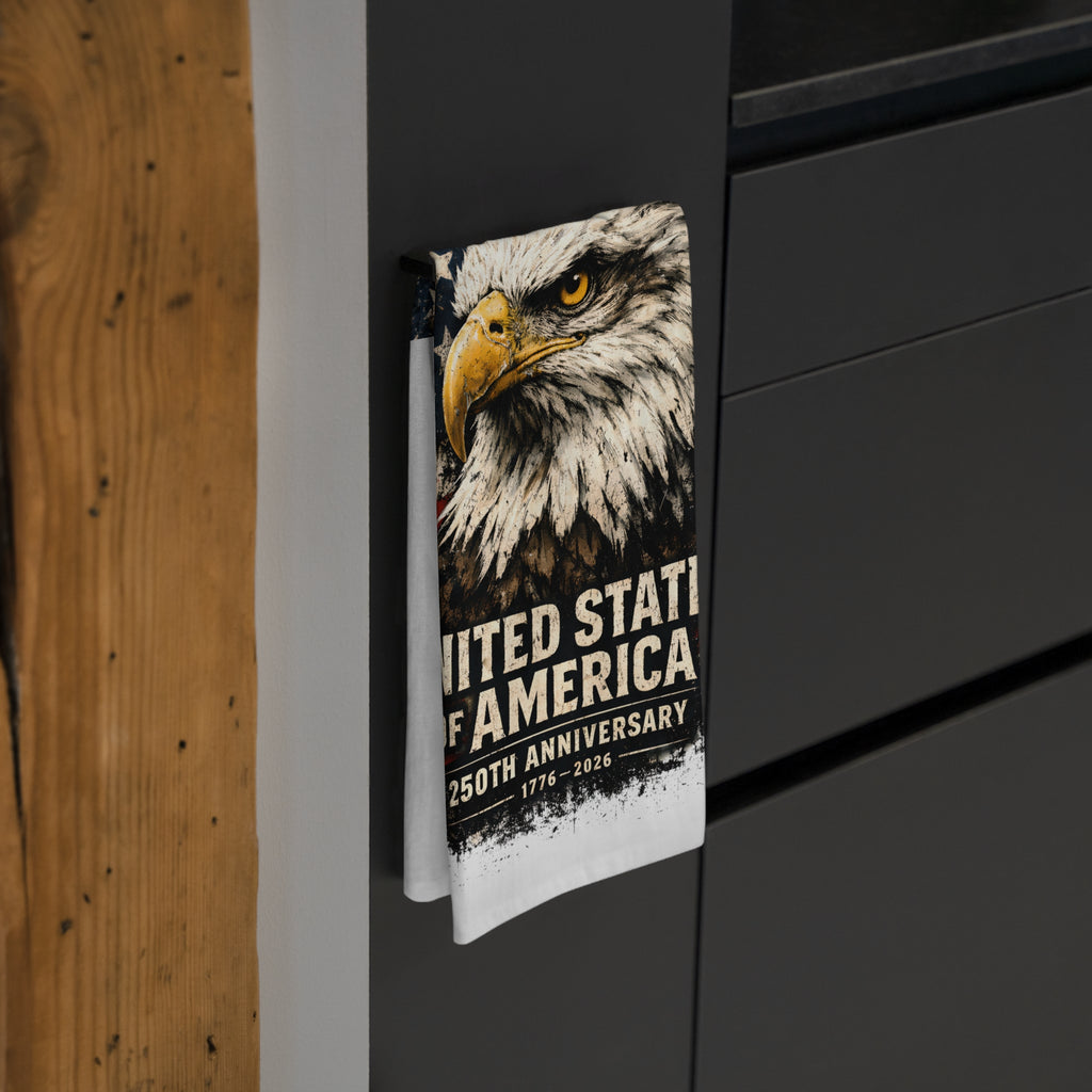 Tea towel with American bald eagle design and text on a black surface.