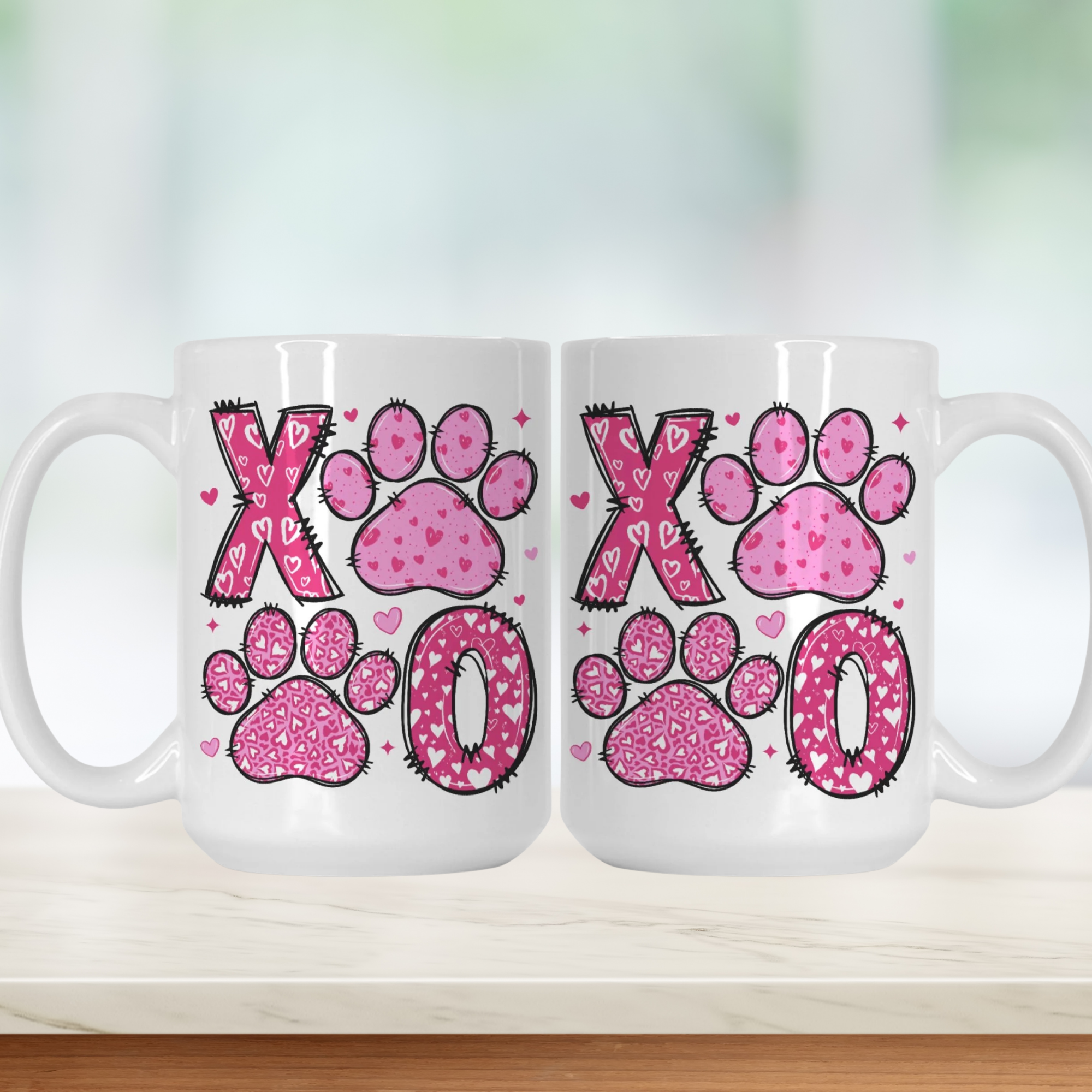 Two white mugs with pink paw print designs on a white background