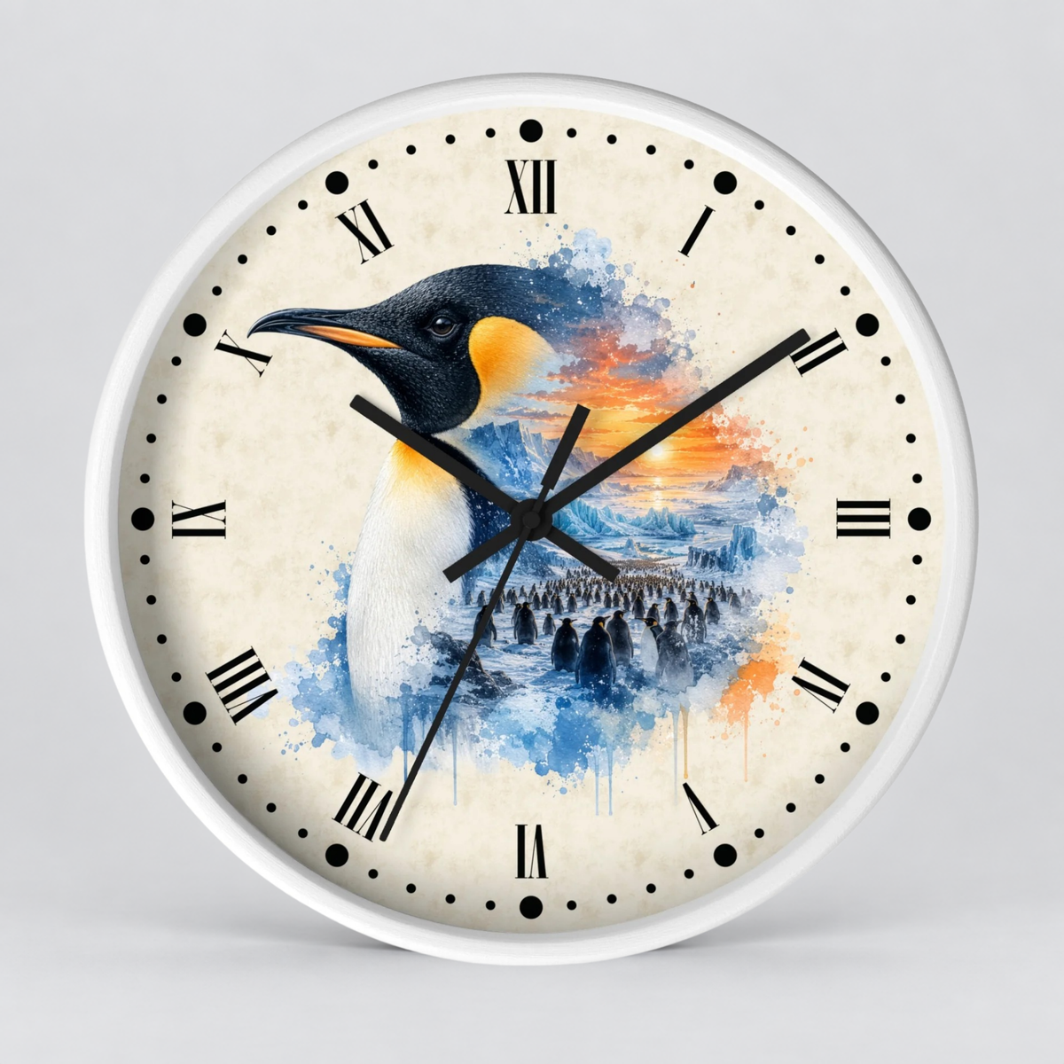 A round wall clock with a white frame and a printed penguin artwork on the face. The clock has black Roman numerals, black dot hour markers, black hands, and a watercolor-style penguin design in blue, white, black, and orange tones on a light cream background.