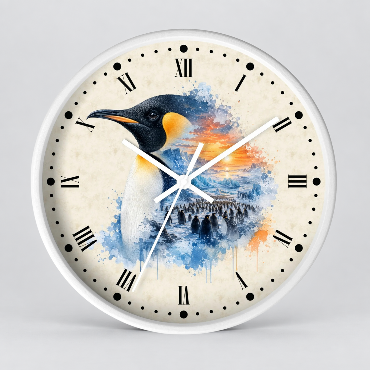 Round wall clock with a white frame and Roman numerals, featuring a watercolor-style penguin illustration in blue, black, white, and orange tones on the face, shown against a light gray background.