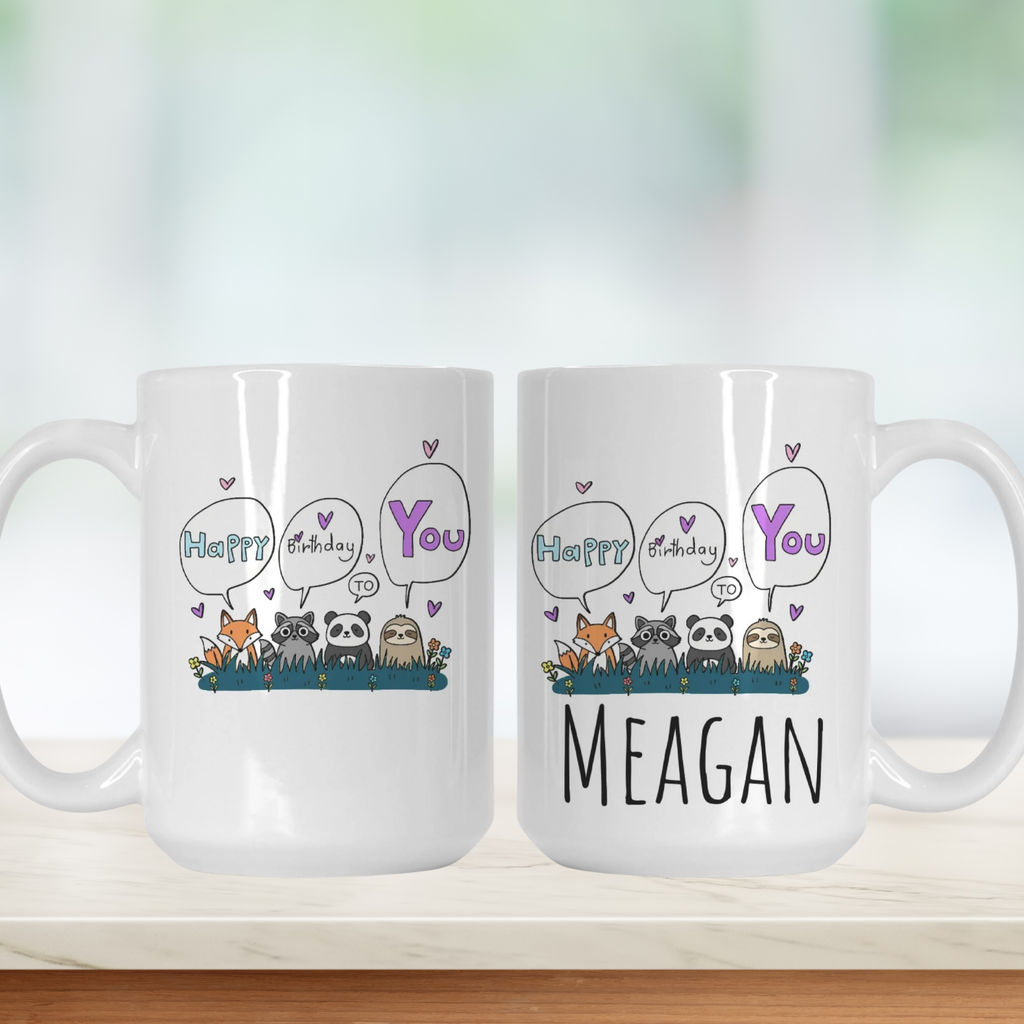 Two white mugs with cartoon animals and personalized Birthday text on a light background