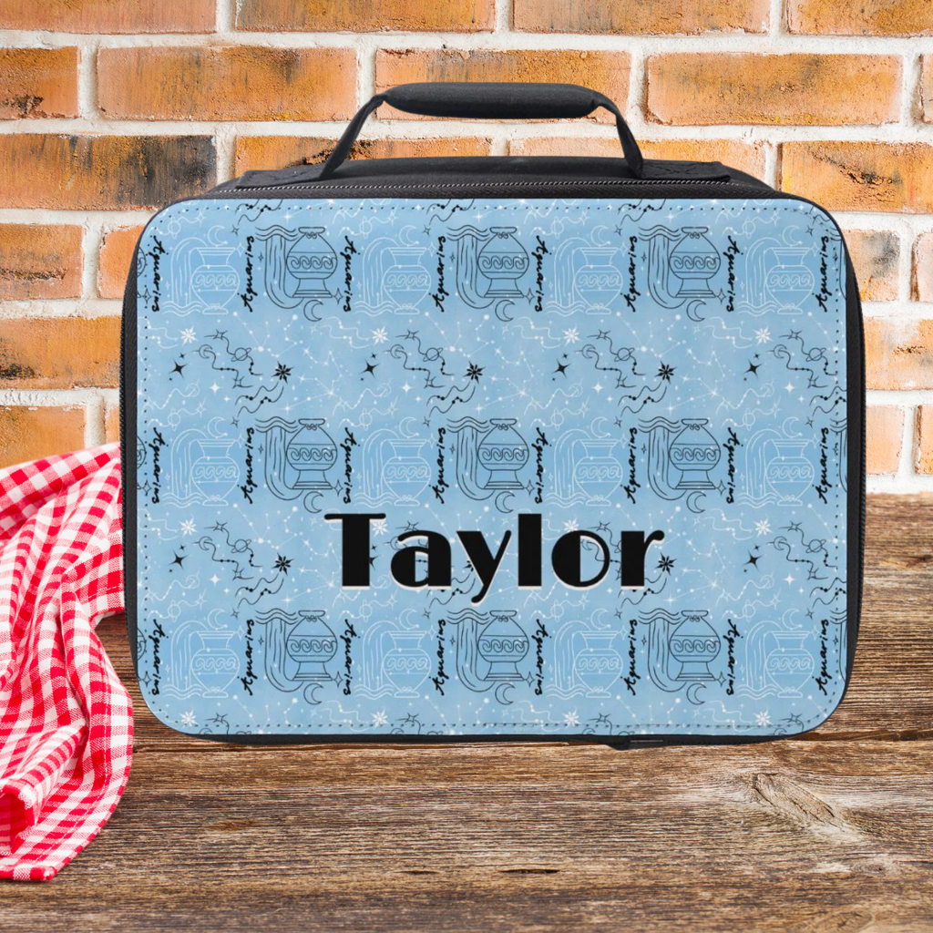 Lunch bag with blue and black Aquarius zodiac pattern and 'Taylor' printed on it against a brick wall background 