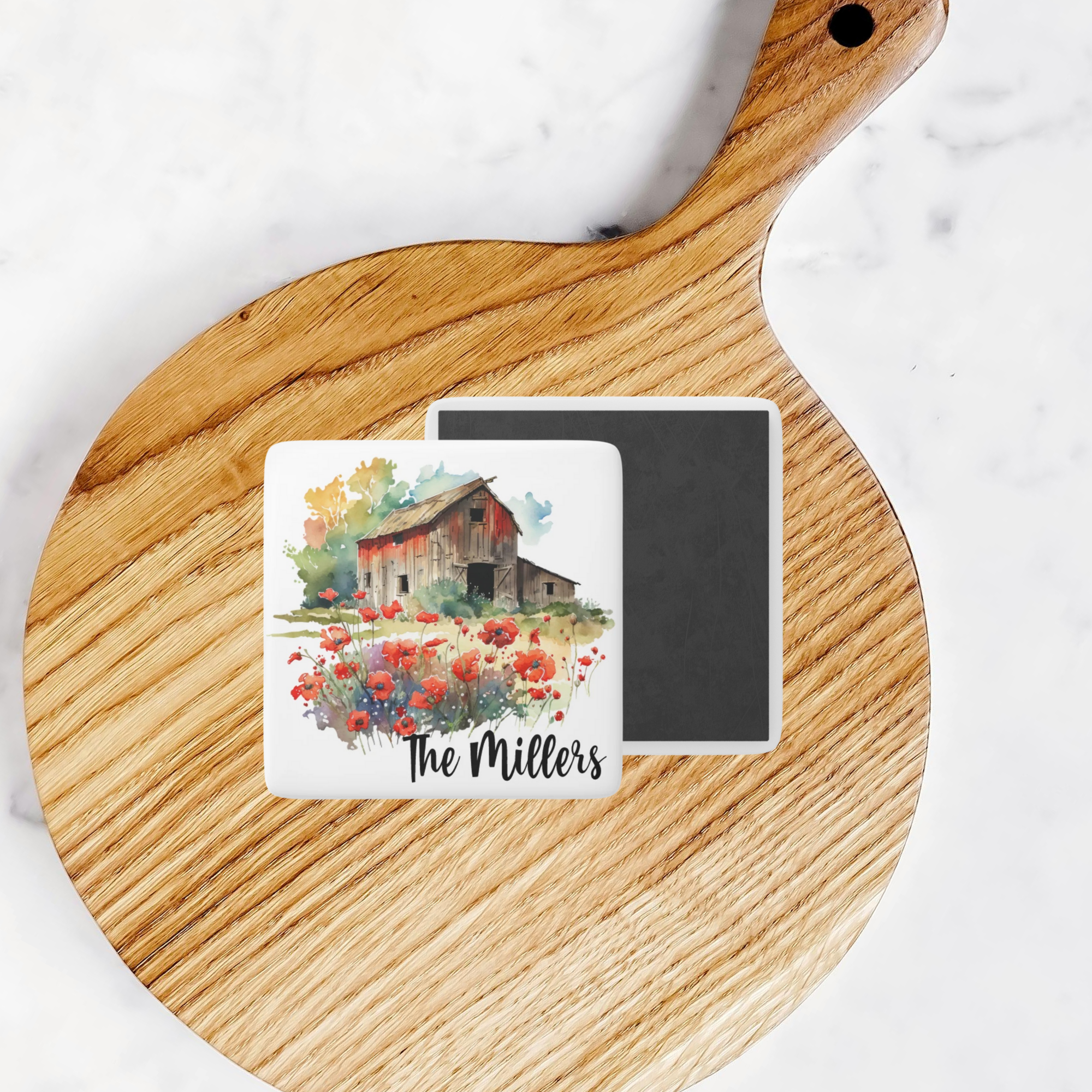 Personalized magnet with barn and flowers design on a wooden cutting board.