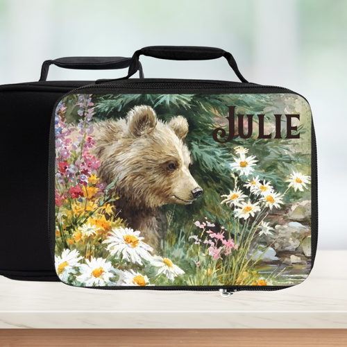  insulated lunch bag with bear design and 'Julie' personalized text on a counter with blurred green background.
