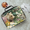 Lunch bag with bear design and 'Julie' text on a cafeteria table with a drink and utensils.