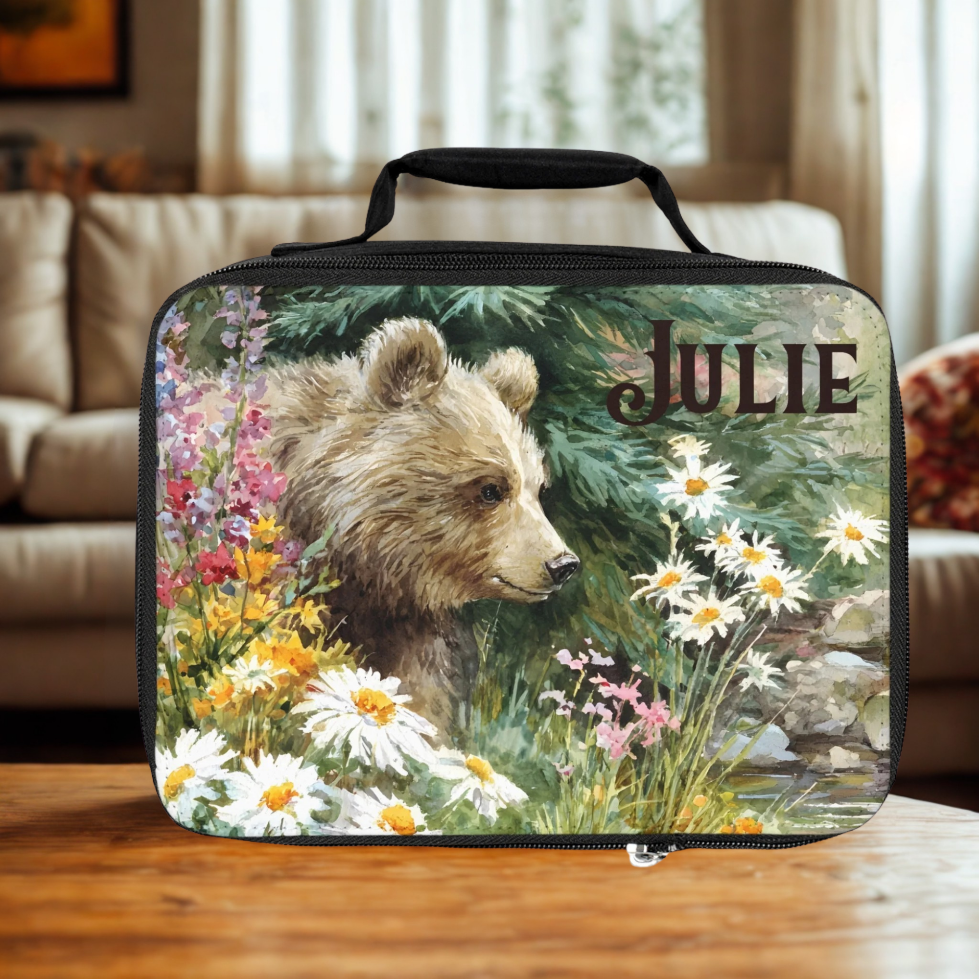  insulated lunch bag with bear design and 'Julie' custom text on a wooden living room table.