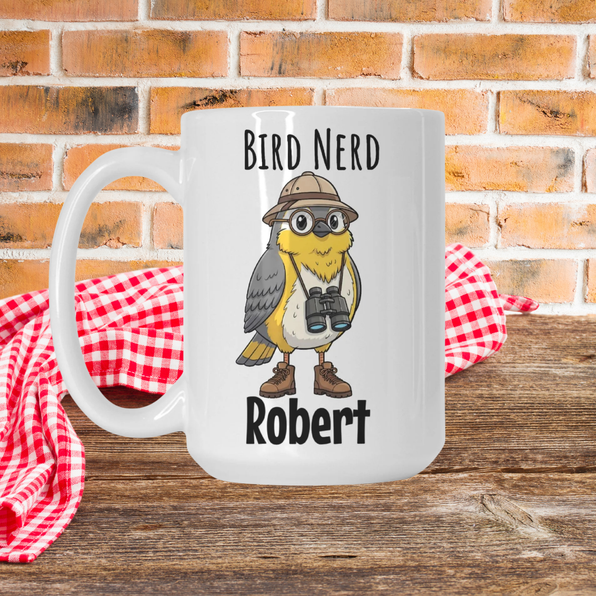 Mug with bird illustration and 'Bird Nerd Robert' text on a wooden picnic table with a brick wall background.