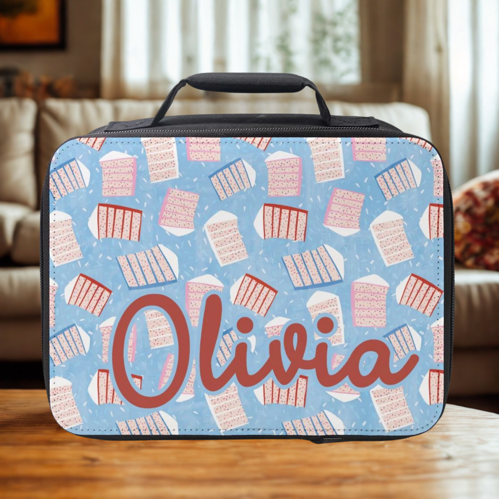  insulated lunch bag with sliced cake pattern and 'Olivia' custom text on a wooden table in a cozy living room.