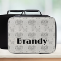 Personalized black and white patterned Cancer zodiac lunch bag with 'Brandy' custom text on a blurred background