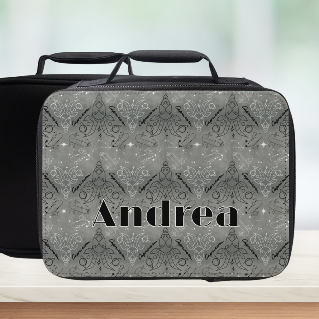 Gray Capricorn patterned lunch bag with 'Andrea' custom text on a blurred background