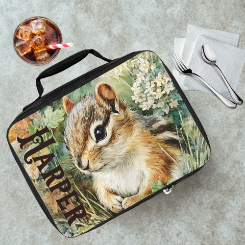 Lunch bag with a chipmunk design and the name 'Harper' on a gray tab;e with a drink and utensils.
