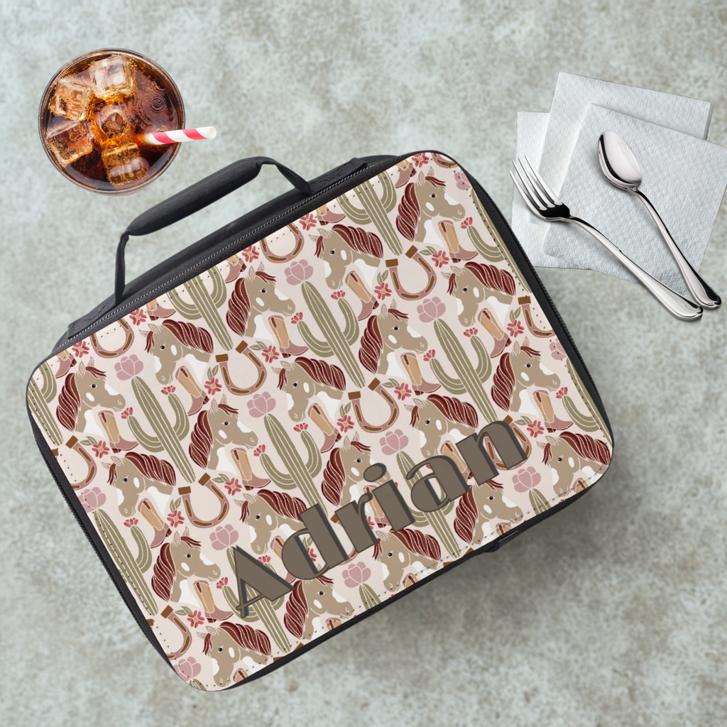 Personalized lunch bag with cactus and horse pattern on a cafeteria table with a drink and utensils.