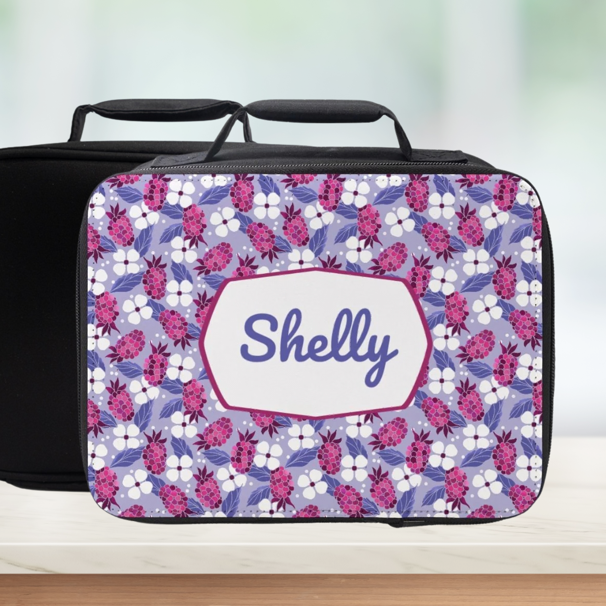 Floral patterned lunch bag with 'Shelly' custom name on a blurred background