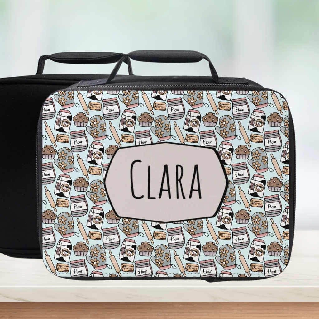  insulated lunch bag with baking-themed pattern and 'CLARA' personalized name on a counter with a light background