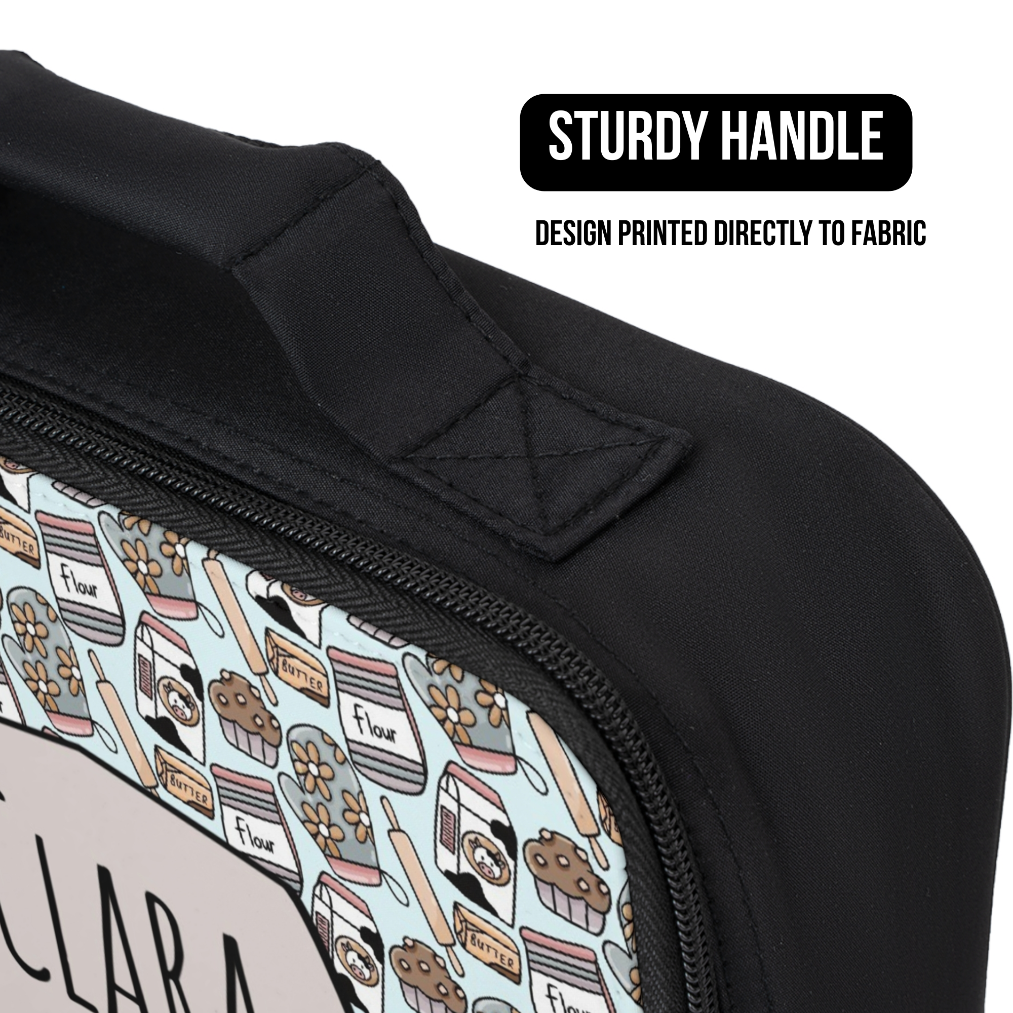 Black lunch bag with a baking pattern  handle and text indicating 'Sturdy Handle' and 'Design Printed Directly to Fabric'.