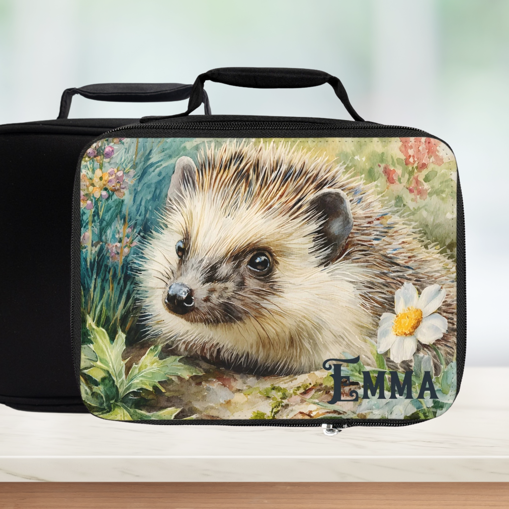 Black lunch bag with a personalized hedgehog design on a counter with a blurred green background.