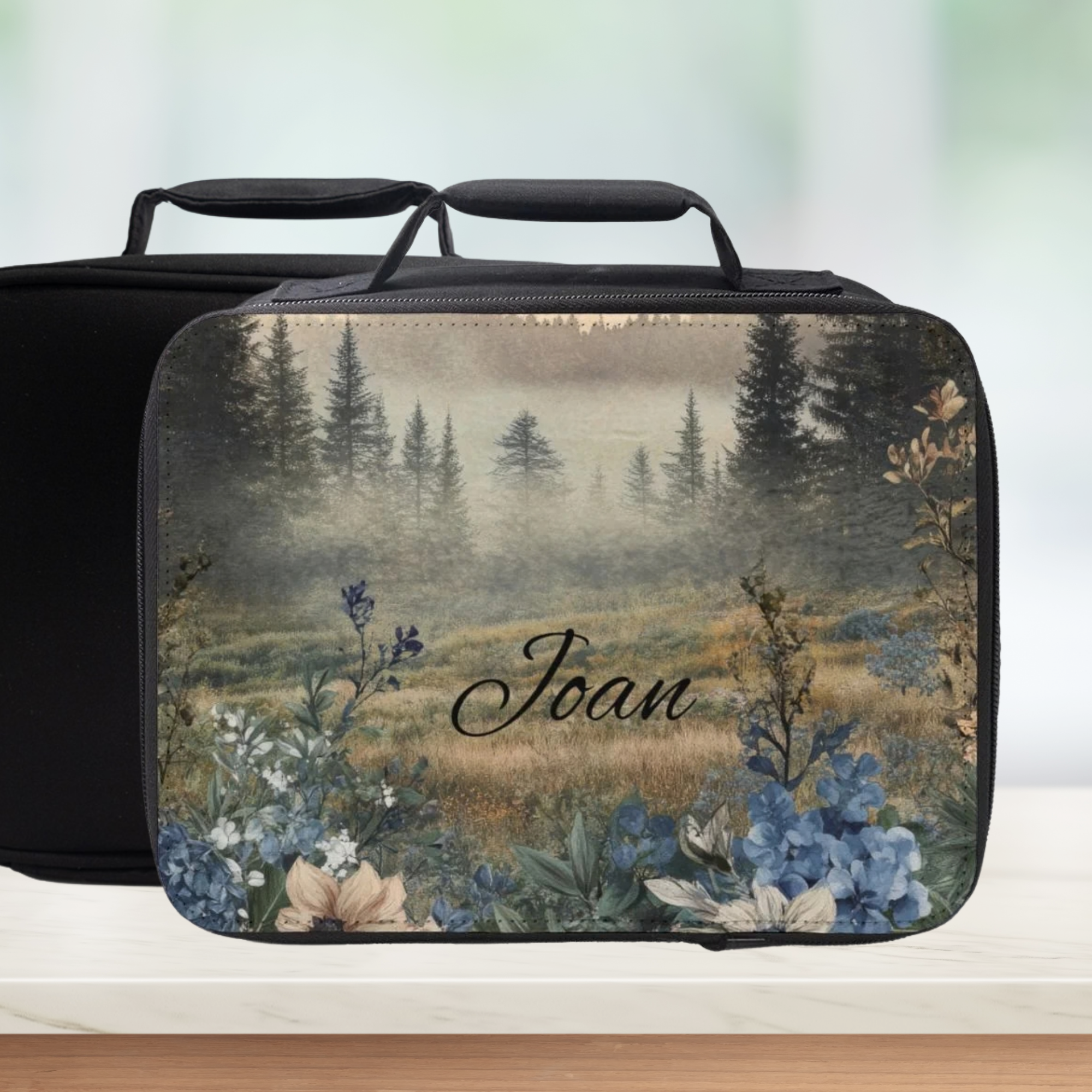 Lunch bag with nature-themed design and 'Joan' text on a blurred background