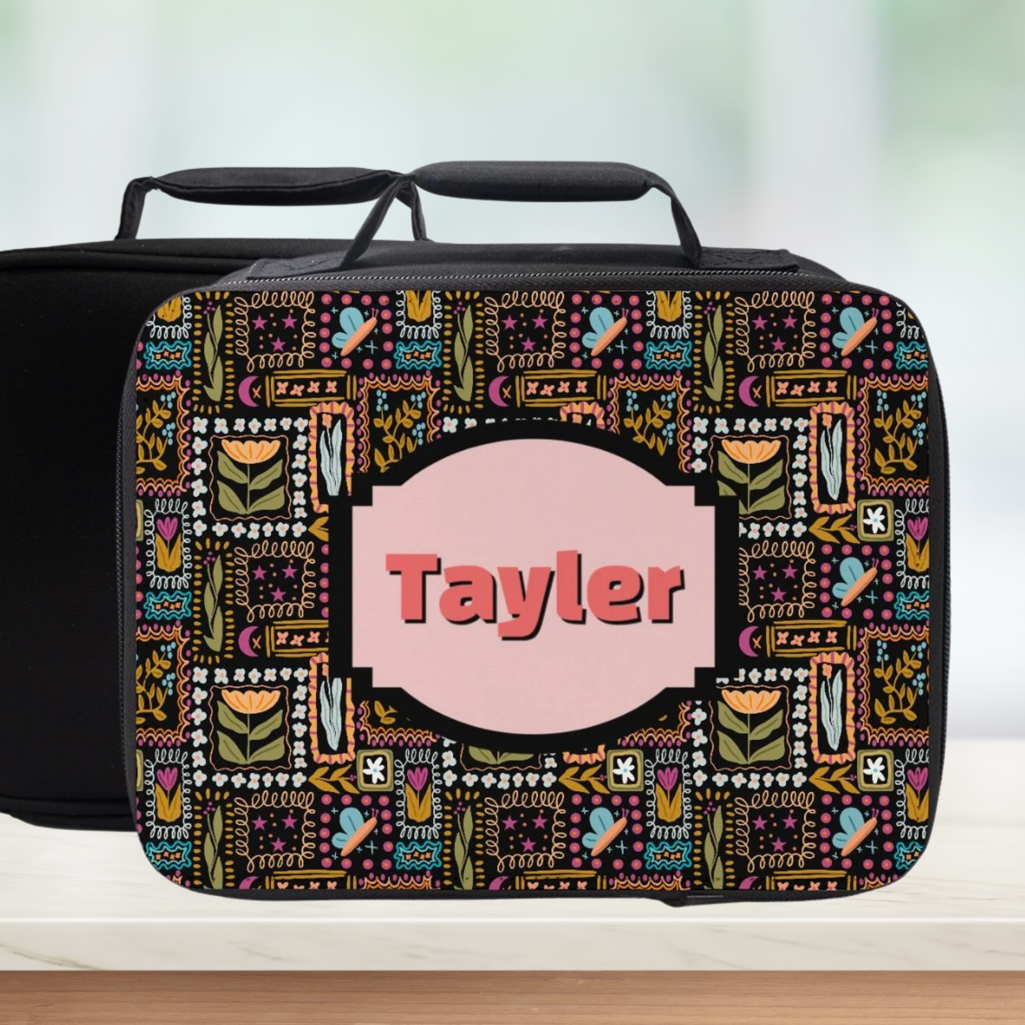 Colorful patterned lunch bag with 'Tayler' on a light background