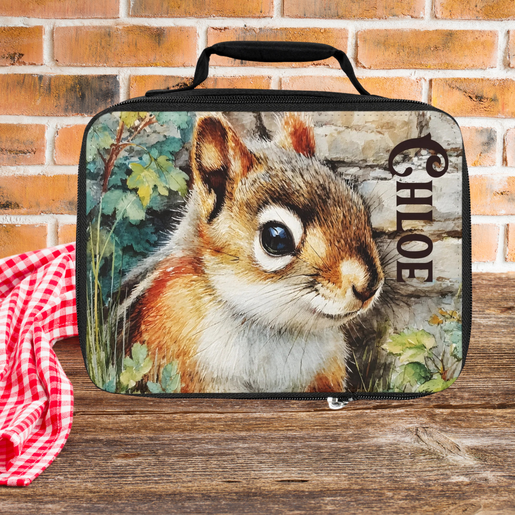 Lunch bag with a chipmunk design and 'Chloe' custom text on a wooden picnic table against  brick wall background