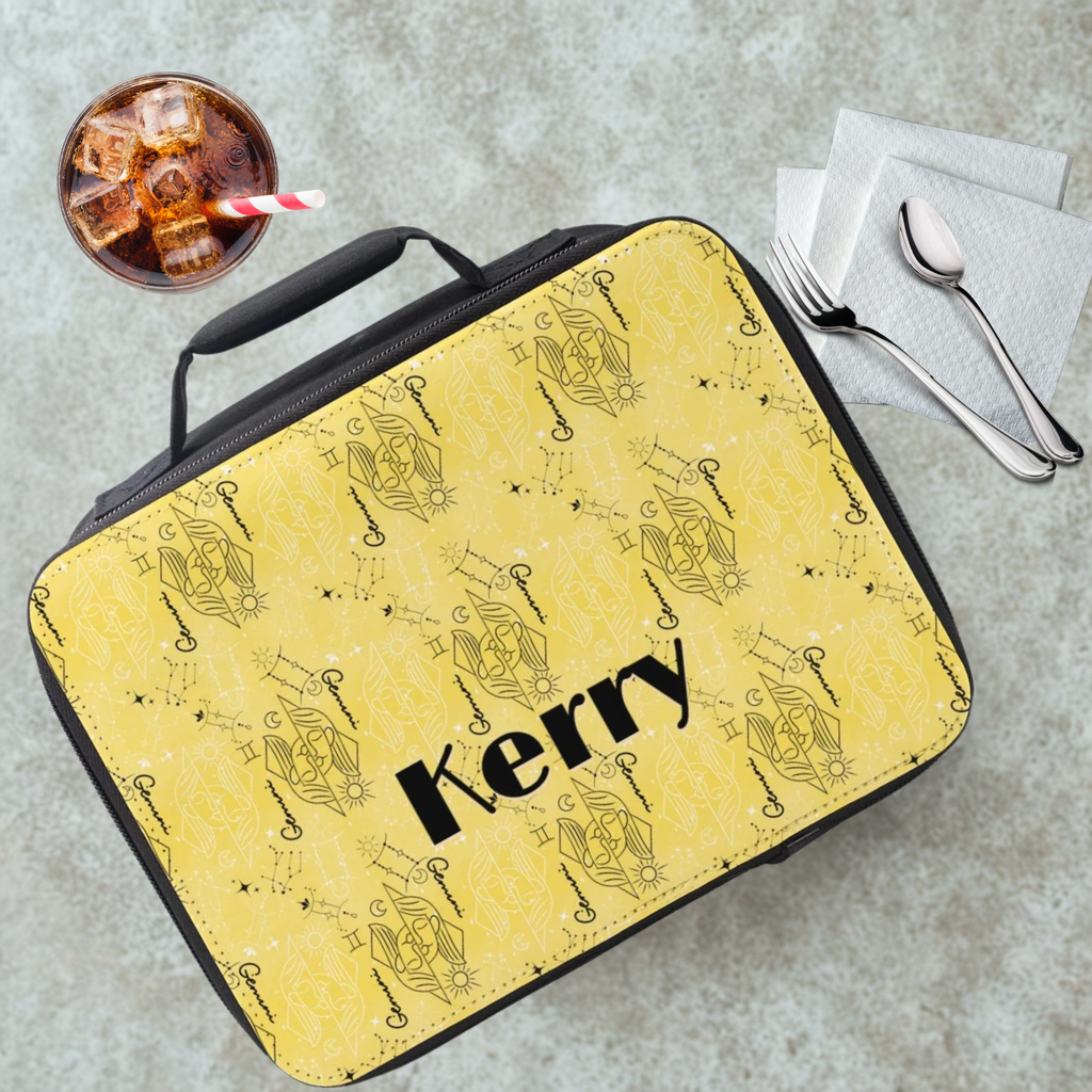insulated lunch bag with yellow and black Gemini zodiac patterns and 'Kerry' custom text on a gray table with a drink and utensils.