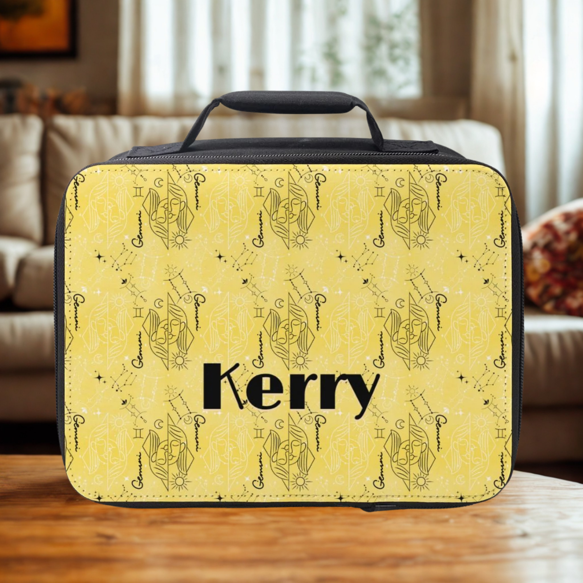 Yellow lunch bag with black zodiac pattern and 'Kerry' custom text on a wooden table in a cozy living room